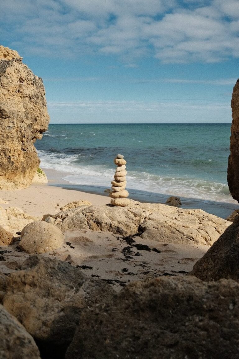 Stack of balanced stones on a sandy beach.
